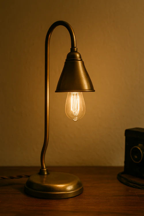 Lampe vintage en laiton posée sur une table en bois, éclairant une pièce avec une ambiance chaleureuse et rétro